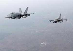 Canadian Air Force fighter CF-18 Hornet and Portuguese Air Force fighter F-16 patrol over Baltics air space, from the Zokniai air base near Siauliai